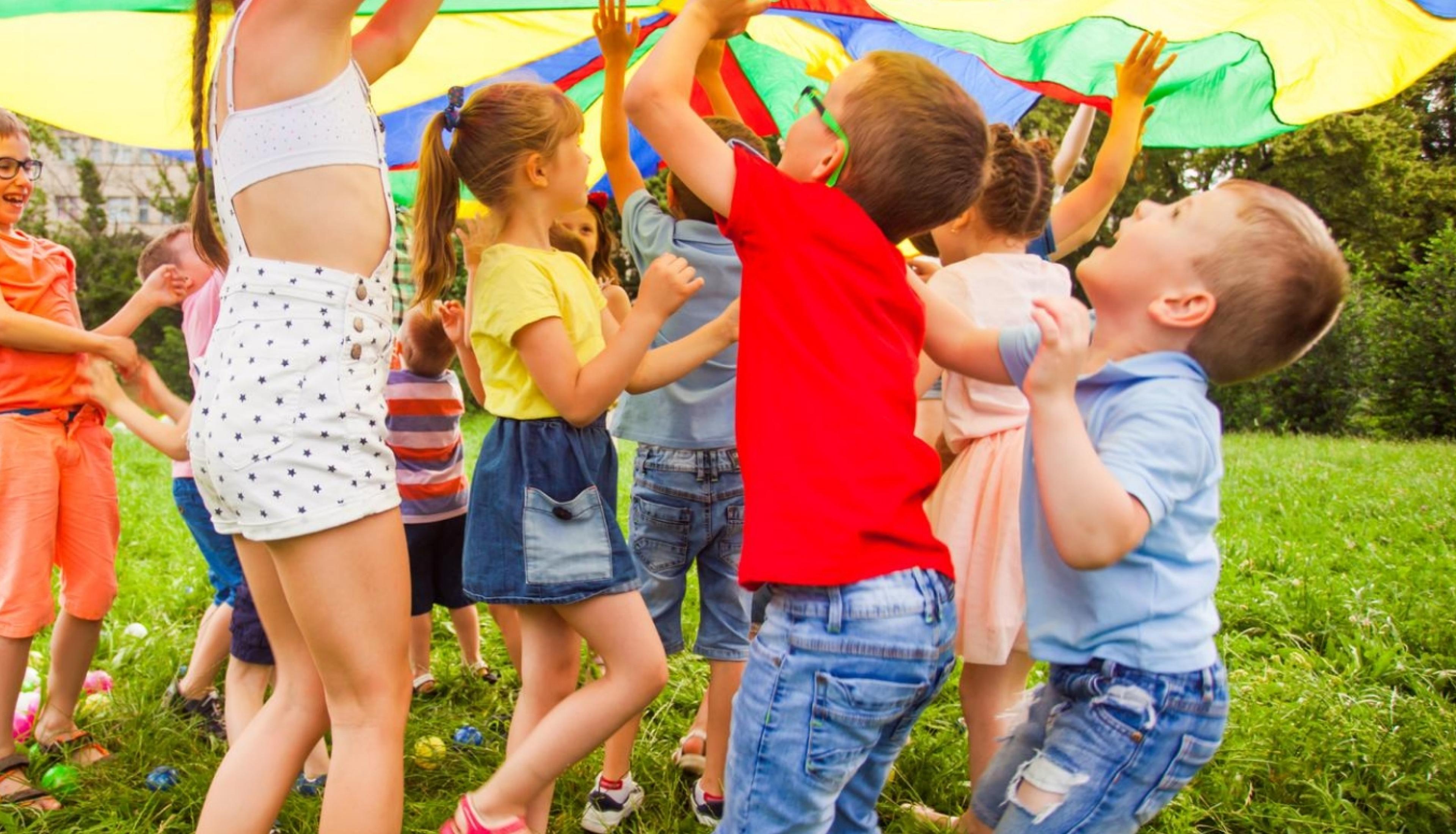 children playing under an umbrella